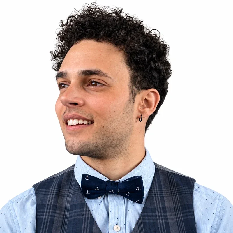 ARBH smiling, in a navy anchor-print bow tie and plaid waistcoat